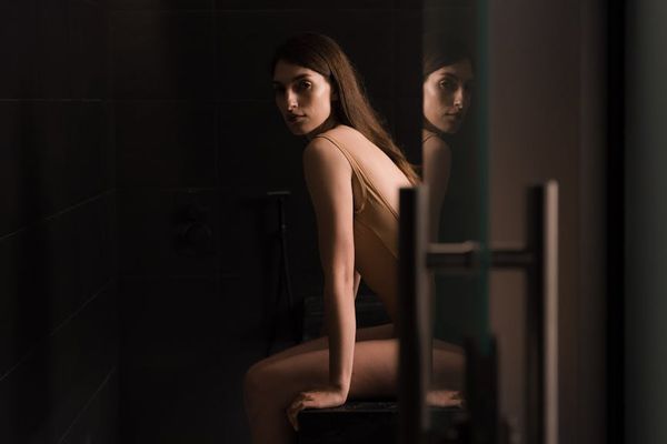 A serene person sitting in a calm, well-lit room, focused.